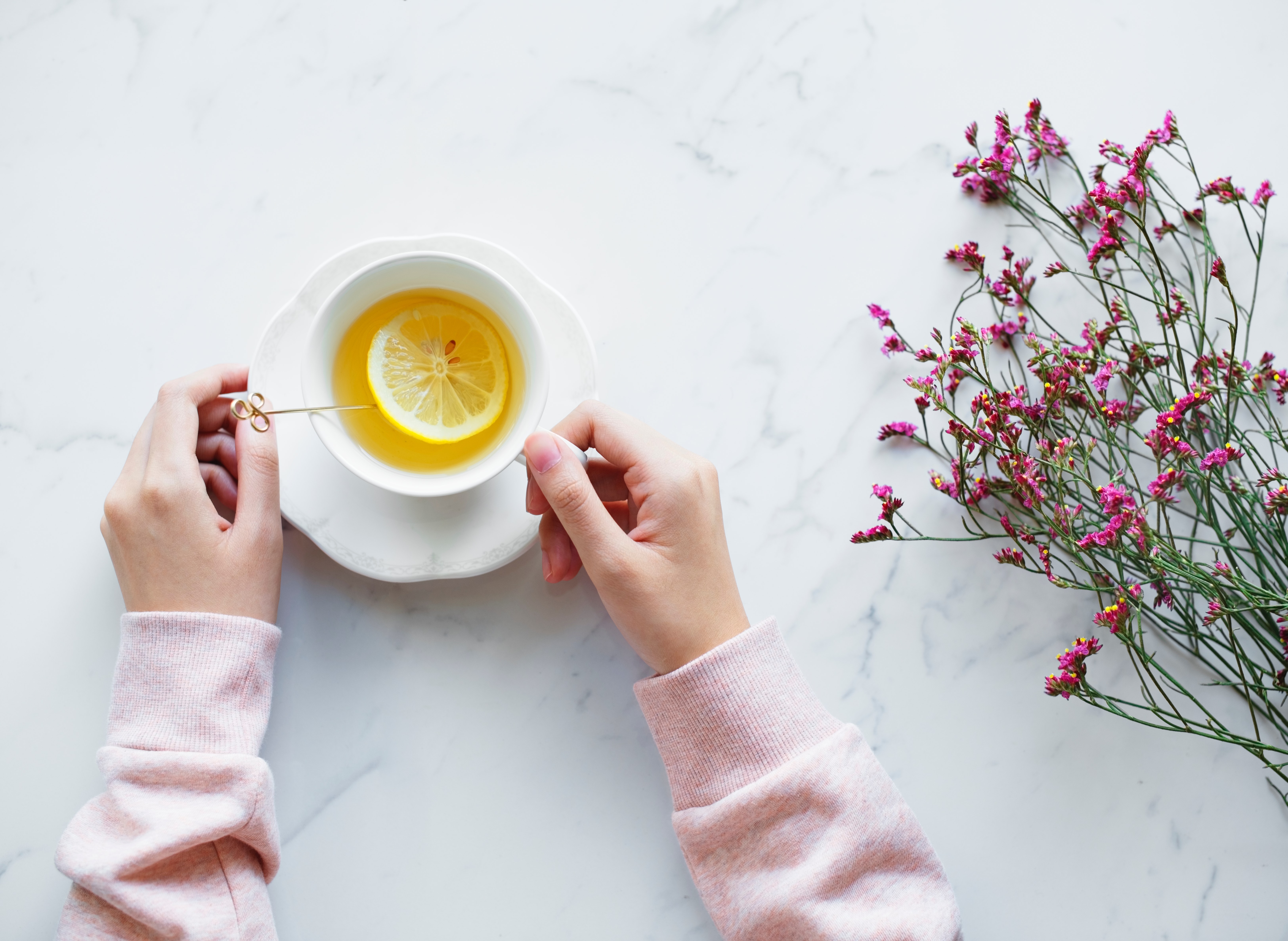 woman holding lemon tea on a marble countertop