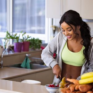 woman cutting up healthy foods in a kitchen