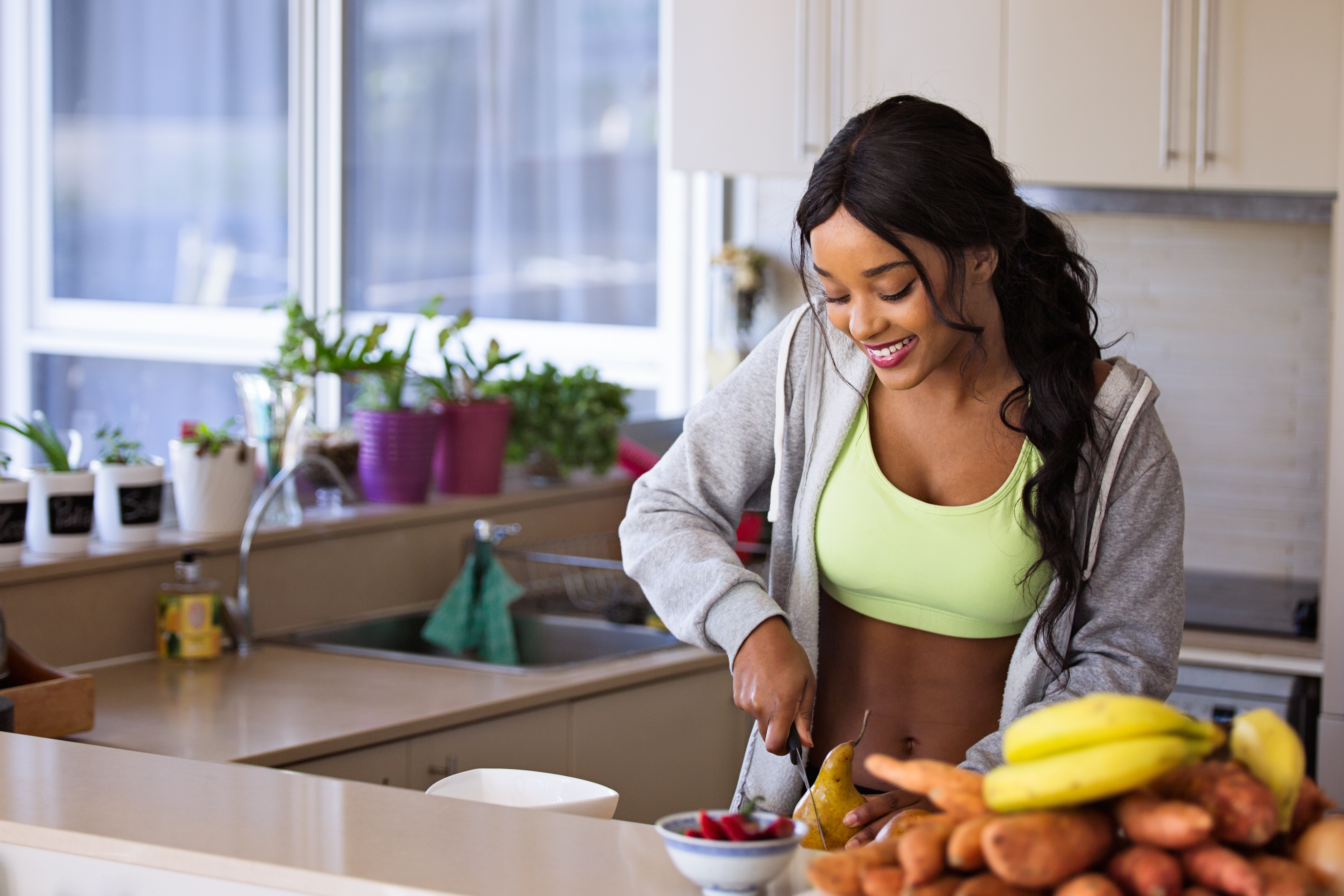 woman cutting up healthy foods in a kitchen