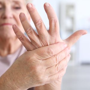 Elderly woman suffering from pain in hand, closeup