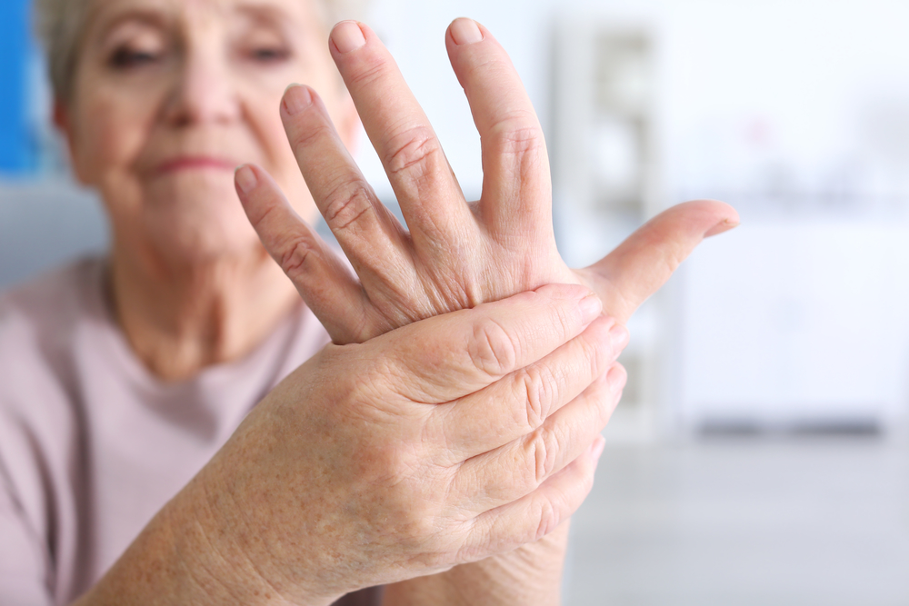 Elderly woman suffering from pain in hand, closeup