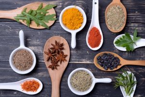 Fresh and dried herb sampler on wooden background